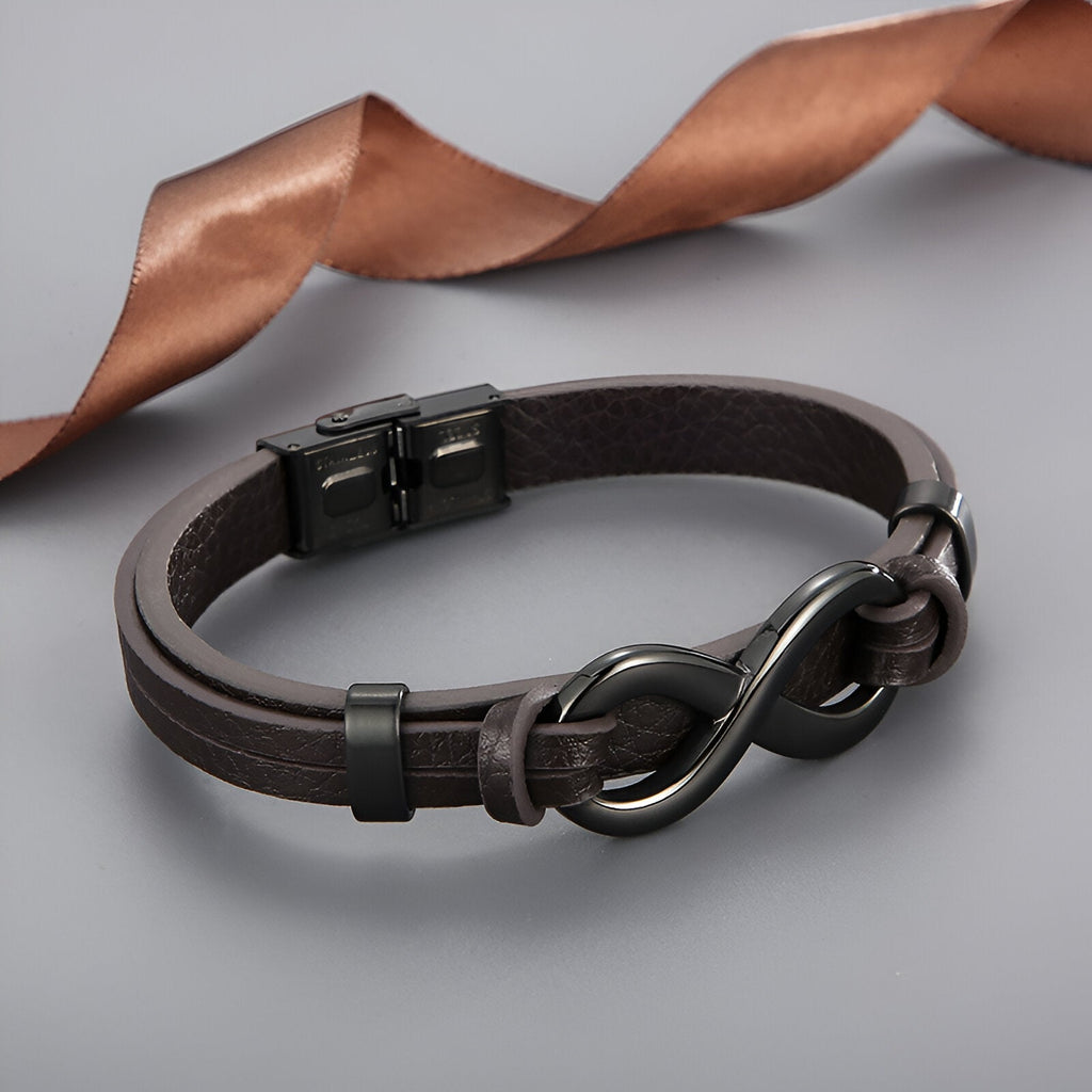 Bracelet en cuir marron foncé avec motif infini en acier inoxydable noir mate et fermeture à clip robuste.