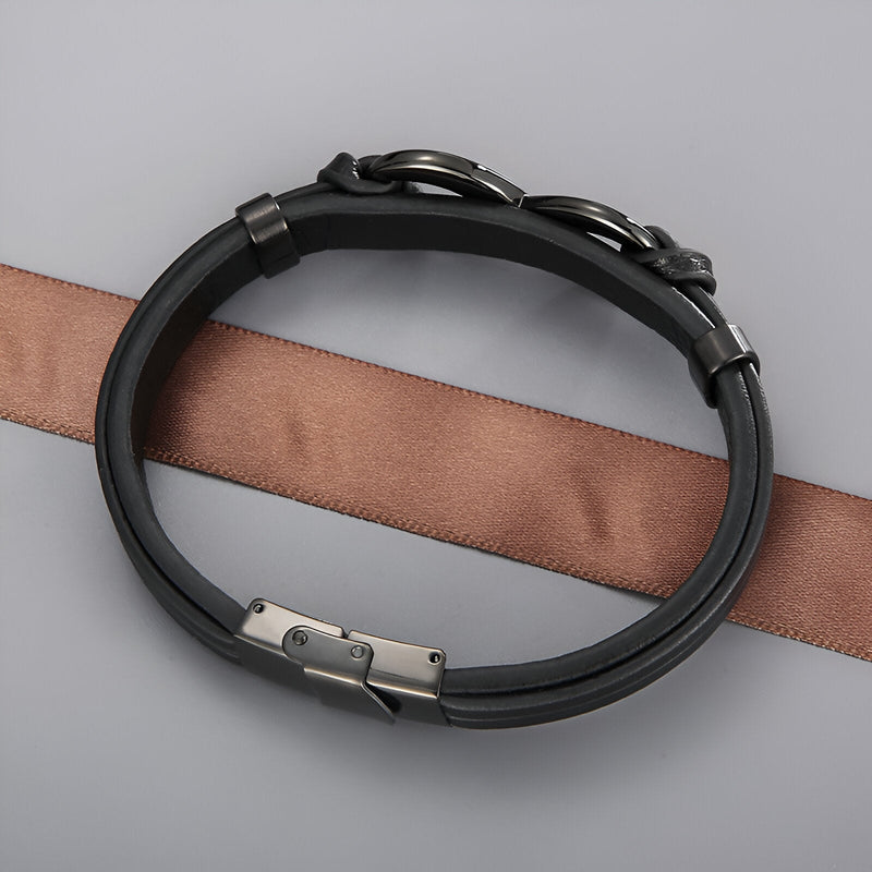 Bracelet noir en cuir avec motif infini en acier inoxydable et fermoir sécurisé.