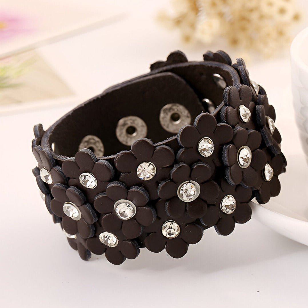 Bracelet manchette en cuir café orné de fleurs découpées et strass brillants.