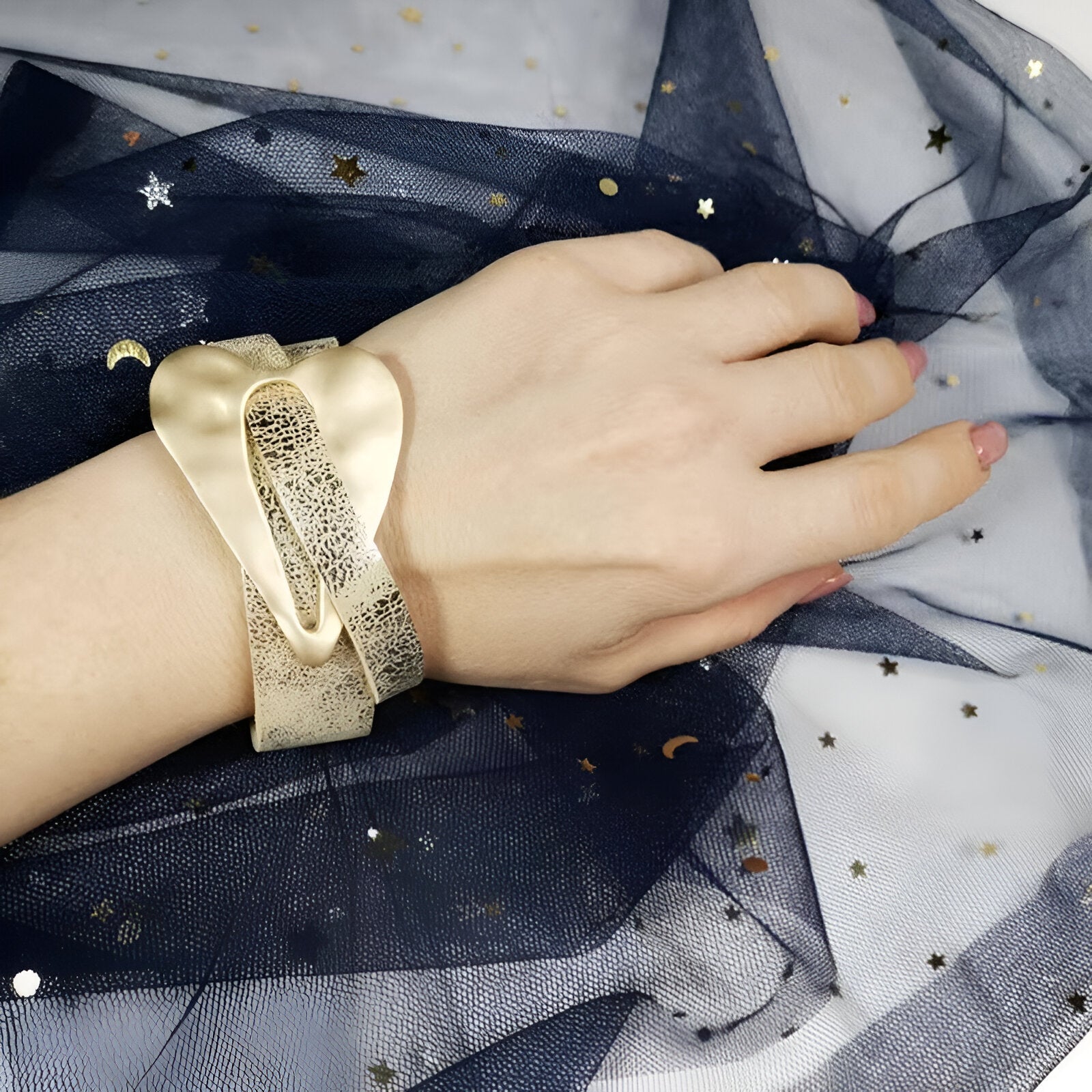Bracelet en cuir microfibre doré avec grand cœur central lisse et fermé par une boucle ajustable.