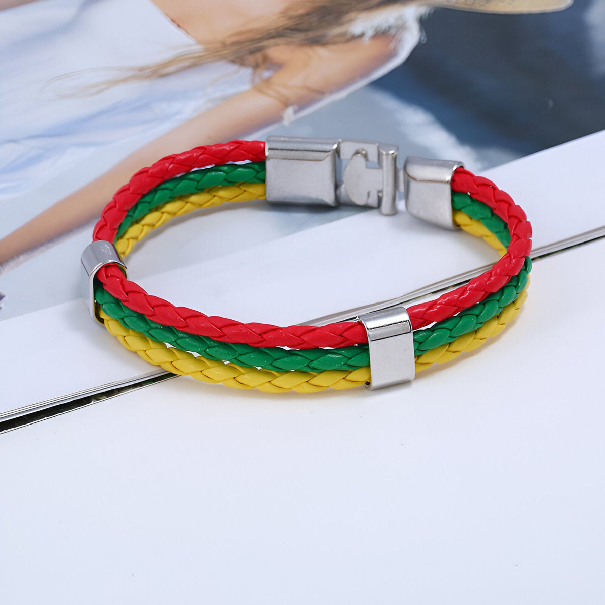 Bracelet en cuir microfibre tressé aux couleurs rouge, vert et jaune avec fermoir métallique argenté.