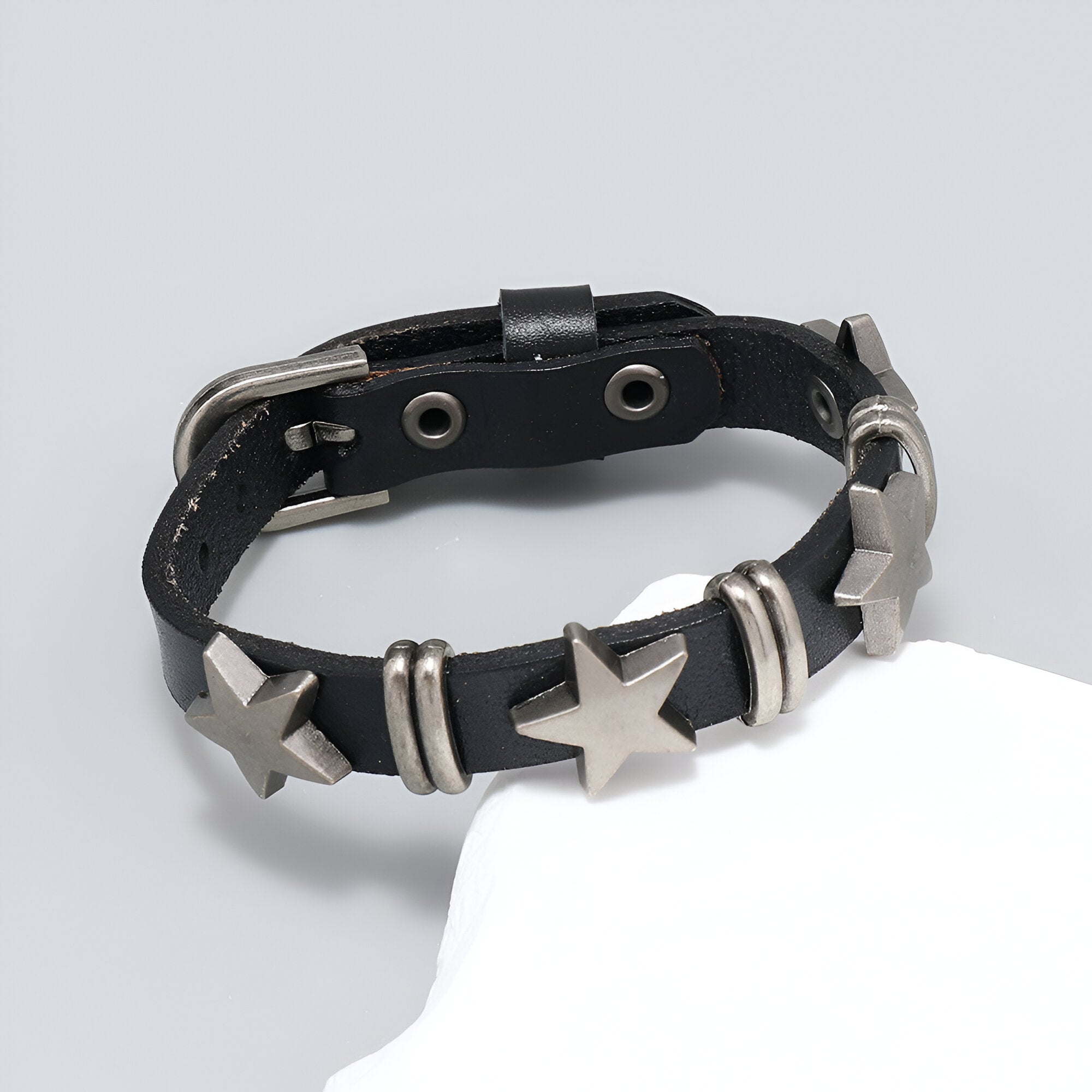 Bracelet en cuir noir pour homme avec étoiles métalliques et boucle argentée ajustable.