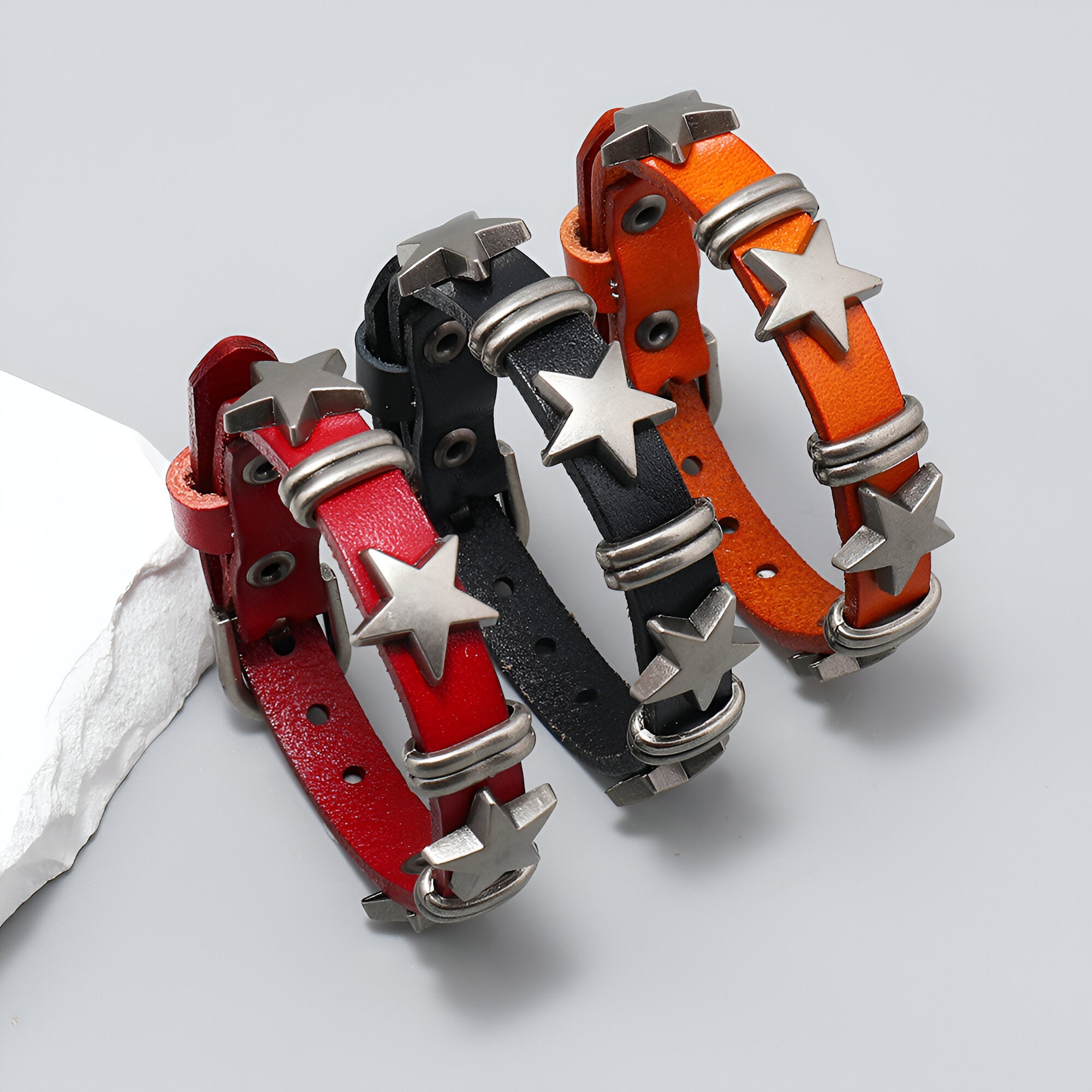 Bracelet en cuir rouge avec motifs étoiles métalliques et boucle réglable.