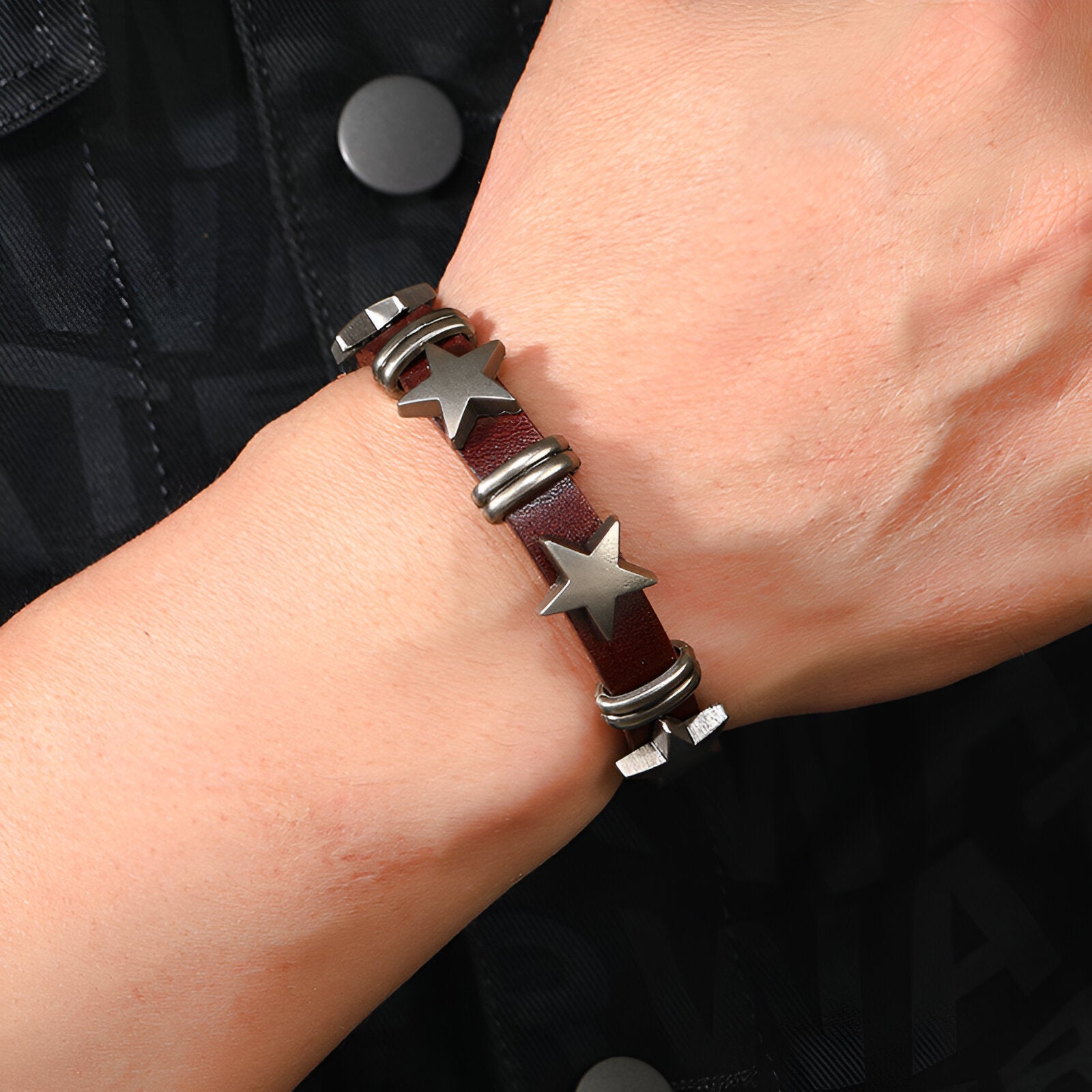 Bracelet en cuir rouge avec étoiles métalliques argentées et anneaux décoratifs pour homme.