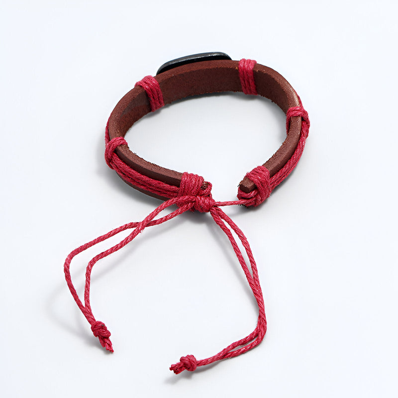 Bracelet homme en cuir marron avec cordons rouges et motif tête de mort en métal.
