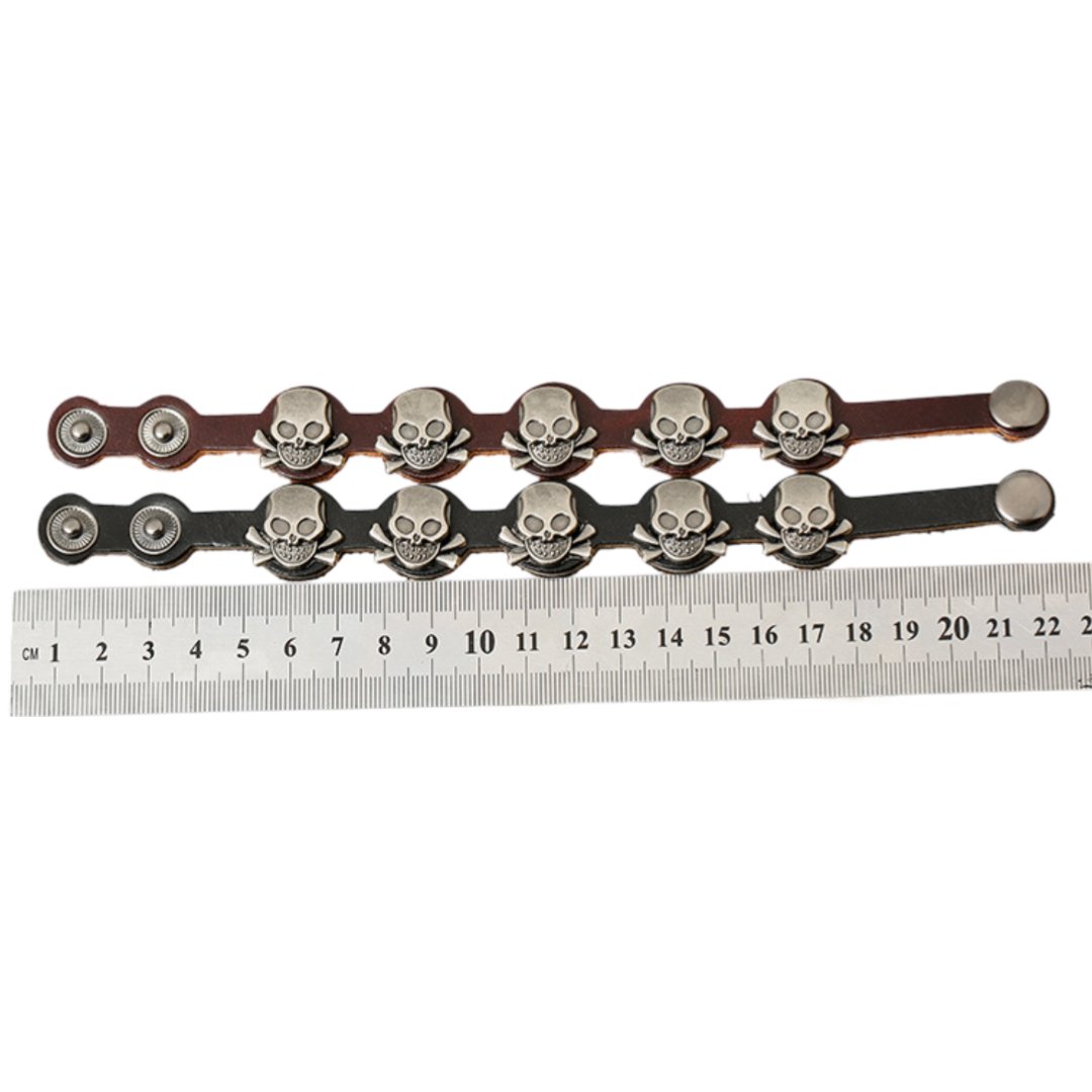 Bracelet en cuir noir avec têtes de mort métalliques et fermeture à pression, style homme.