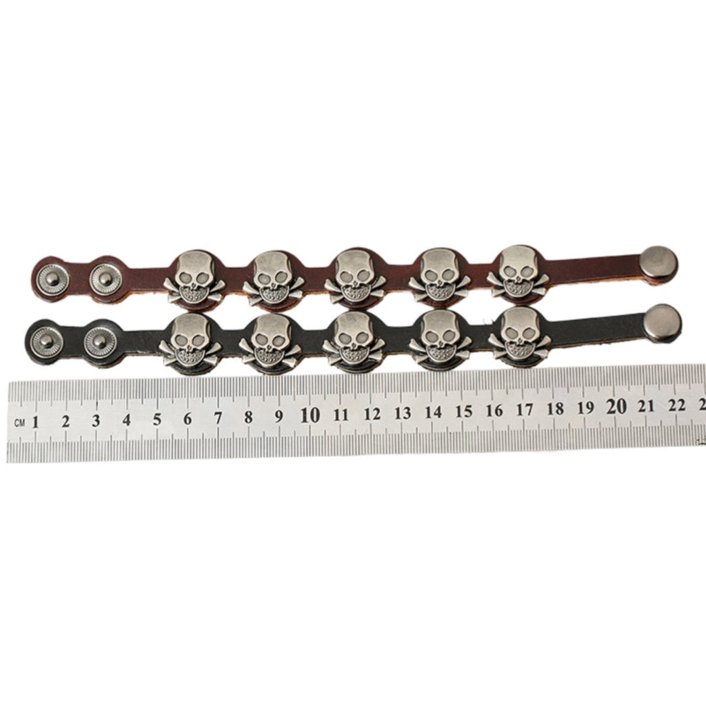 Bracelet en cuir noir avec têtes de mort métalliques et fermeture à pression, style homme.