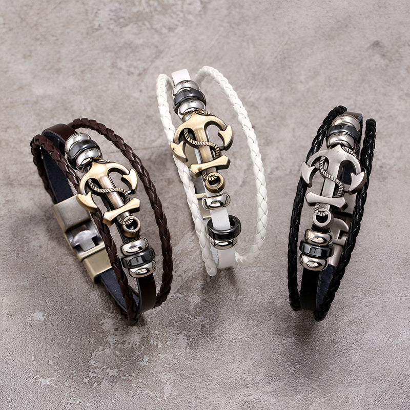 Bracelet multi-rangs en cuir marron avec ancre marine métallique dorée et détails argentés.