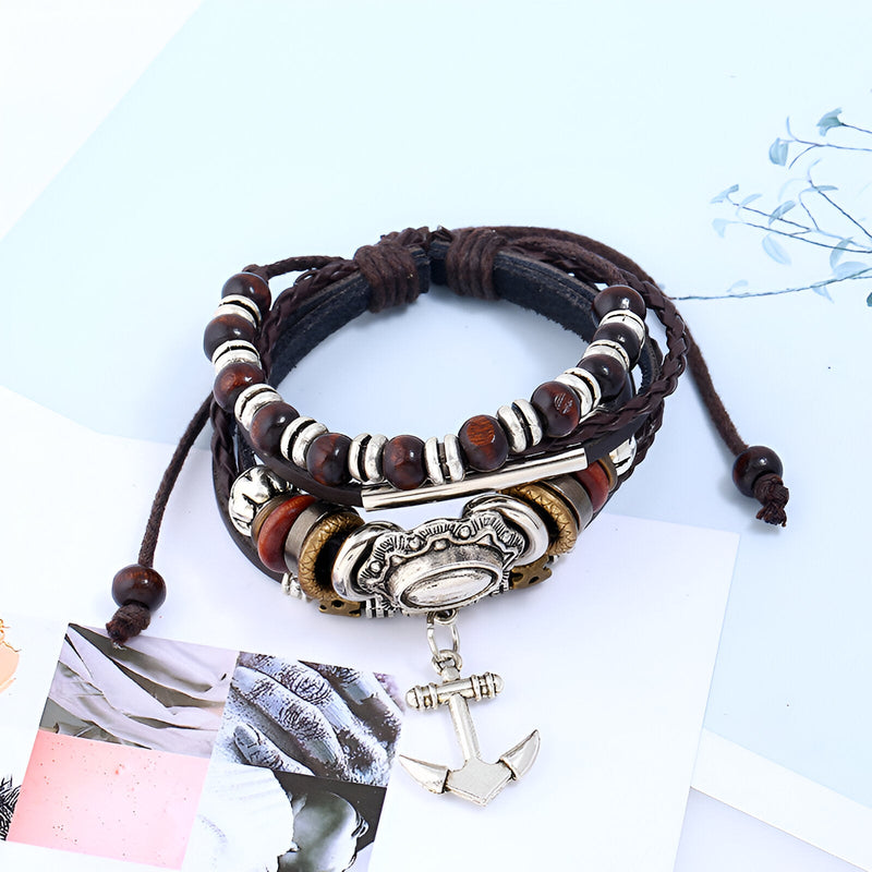 Bracelet multi-rangs en cuir marron avec charm ancre argentée et détails métalliques, style mixte.
