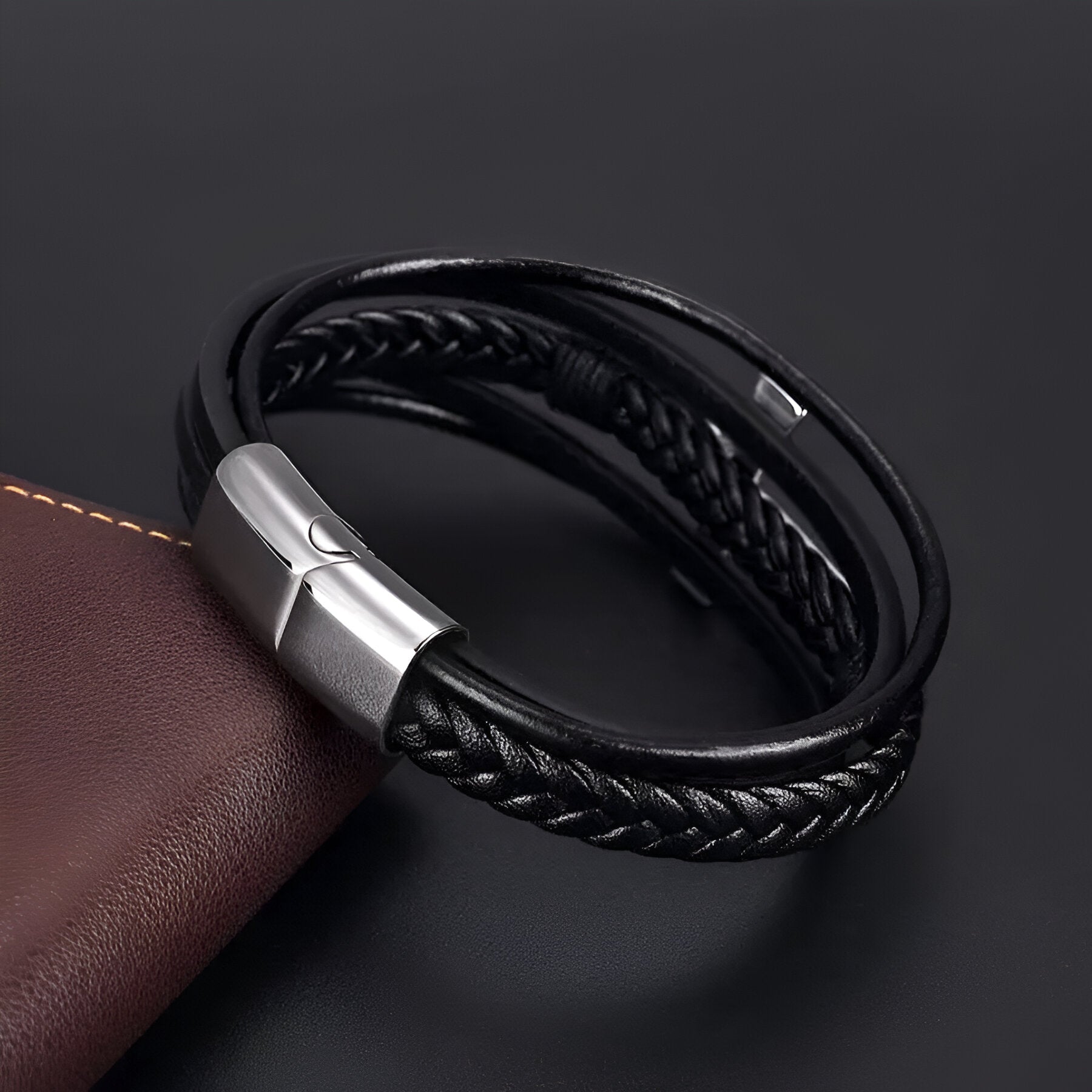 Bracelet noir multi-rangs en cuir avec motif croix et fermoir argenté mat.
