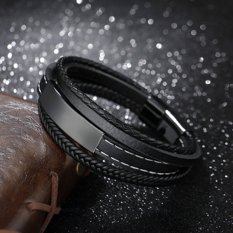 Bracelet multi-rangs en cuir noir avec plaque métallique et détails tressés, style tendance Clément.