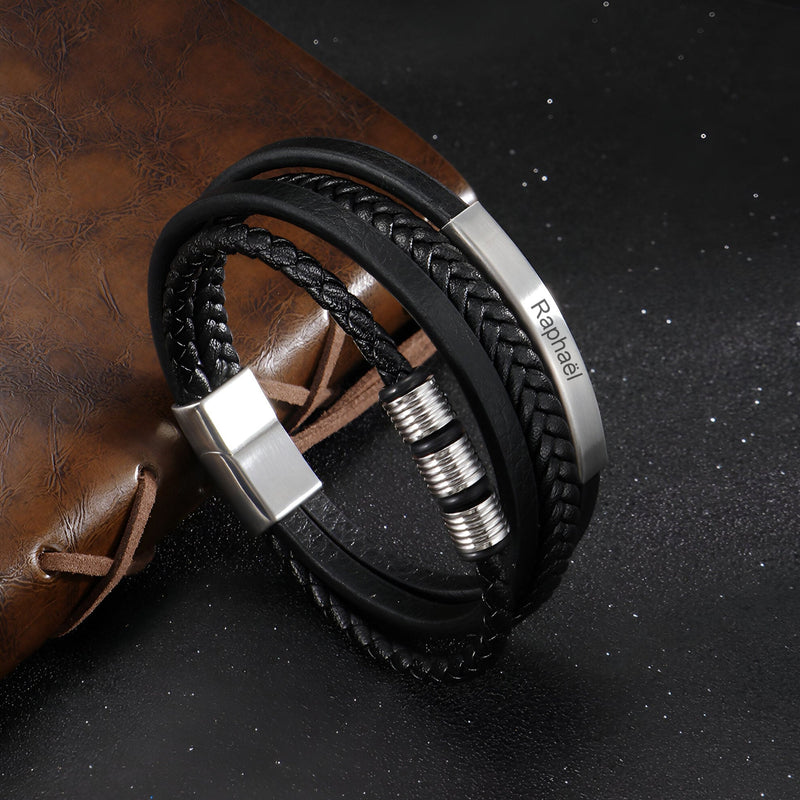 Bracelet multi-rangs en cuir noir tressé avec fermoir et détails argentés personnalisés.