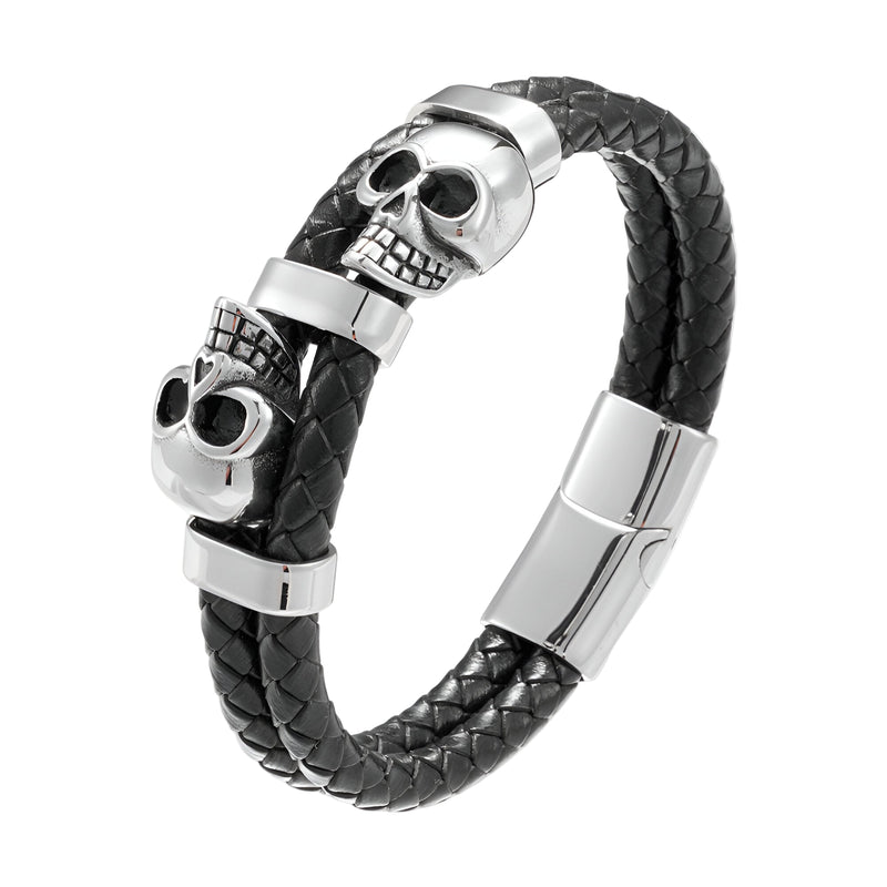 Bracelet en cuir noir tressé avec ornement double têtes de mort en métal argenté et fermoir magnétique.