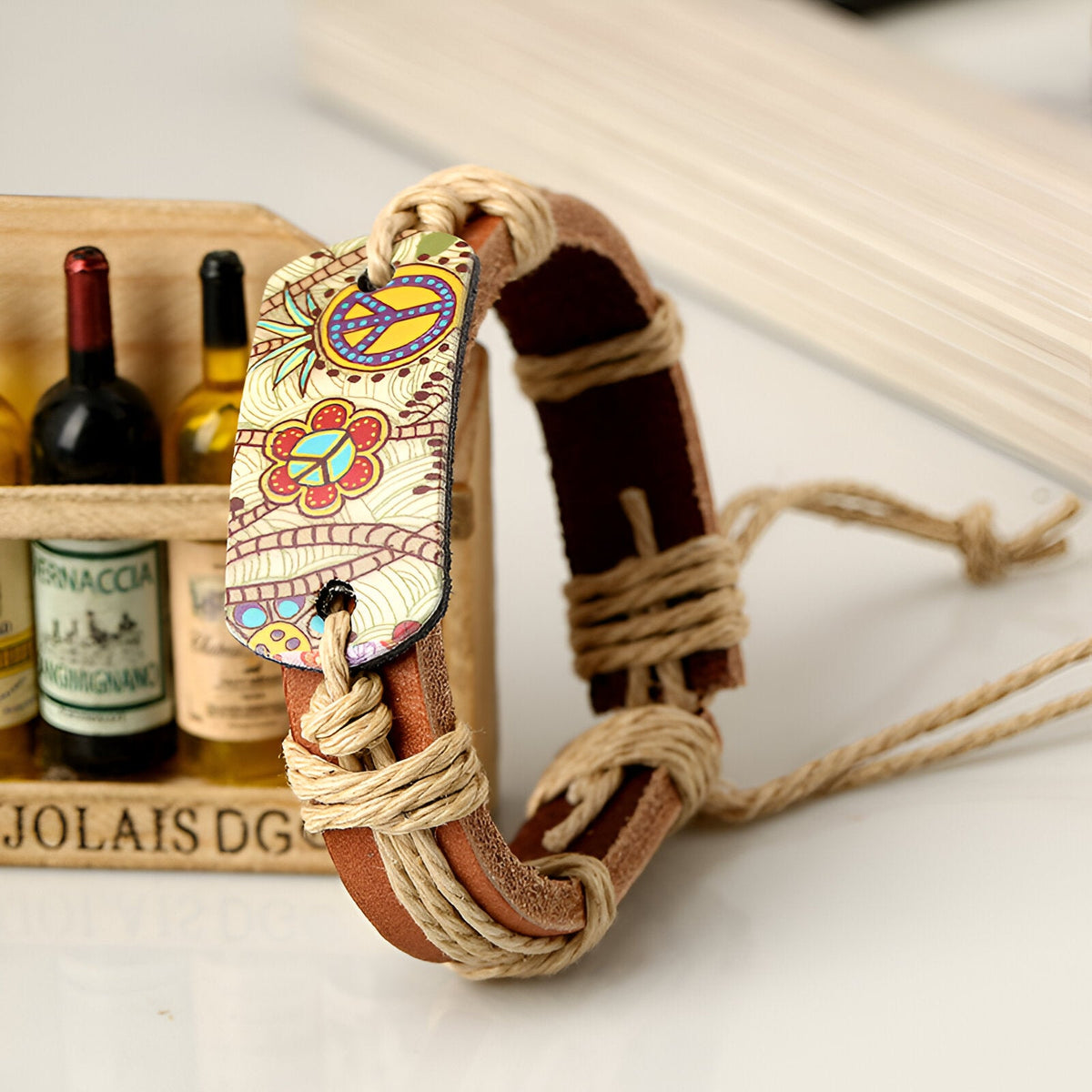 Bracelet en cuir marron avec cordons beige et motifs peace and love colorés.