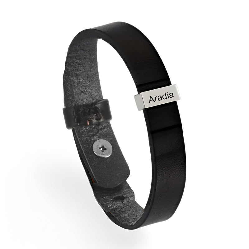 Bracelet en cuir noir avec plaque métallique gravée et fermoir à bouton-pression.