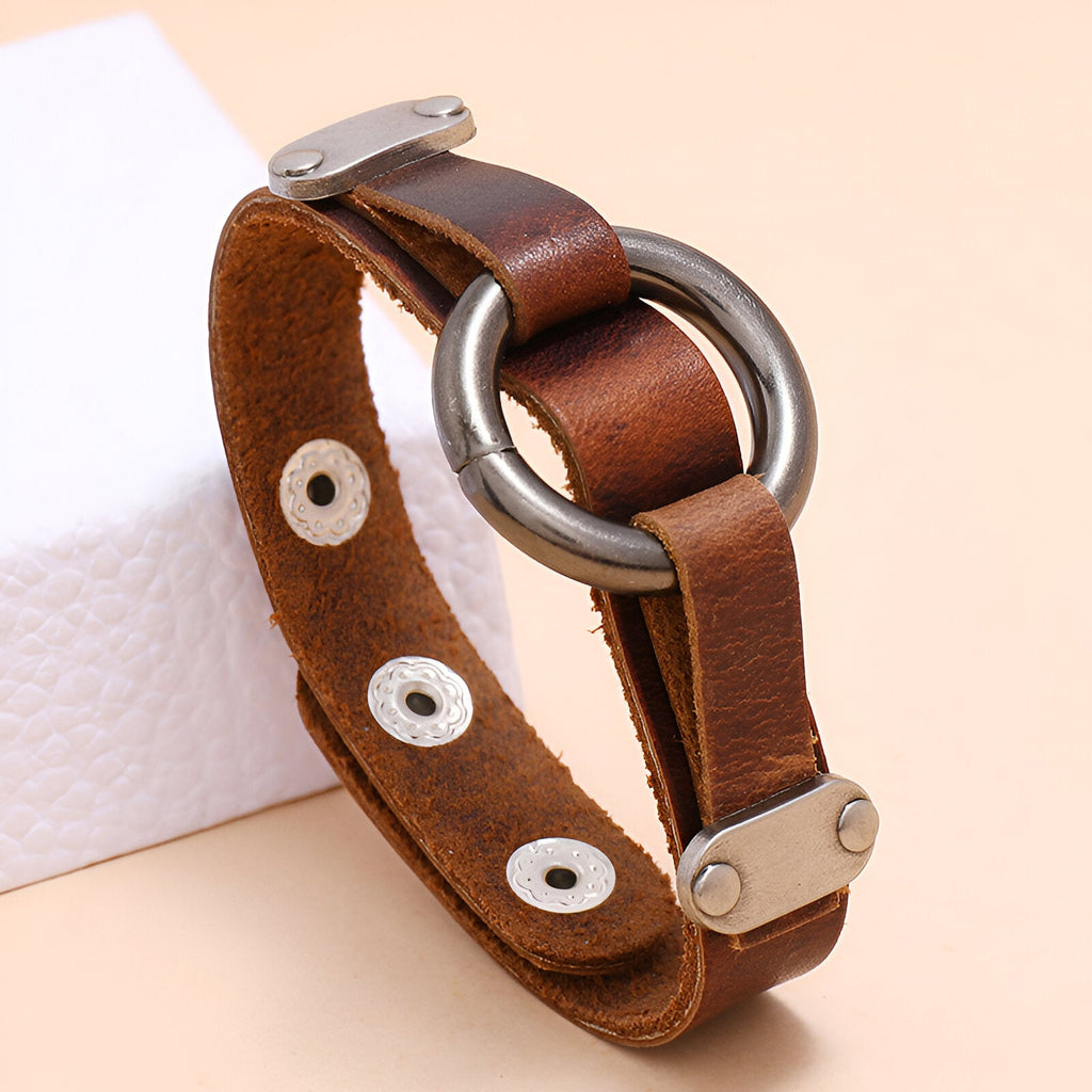 Bracelet en cuir marron pour homme avec anneau métallique argenté et fermoir à pression.