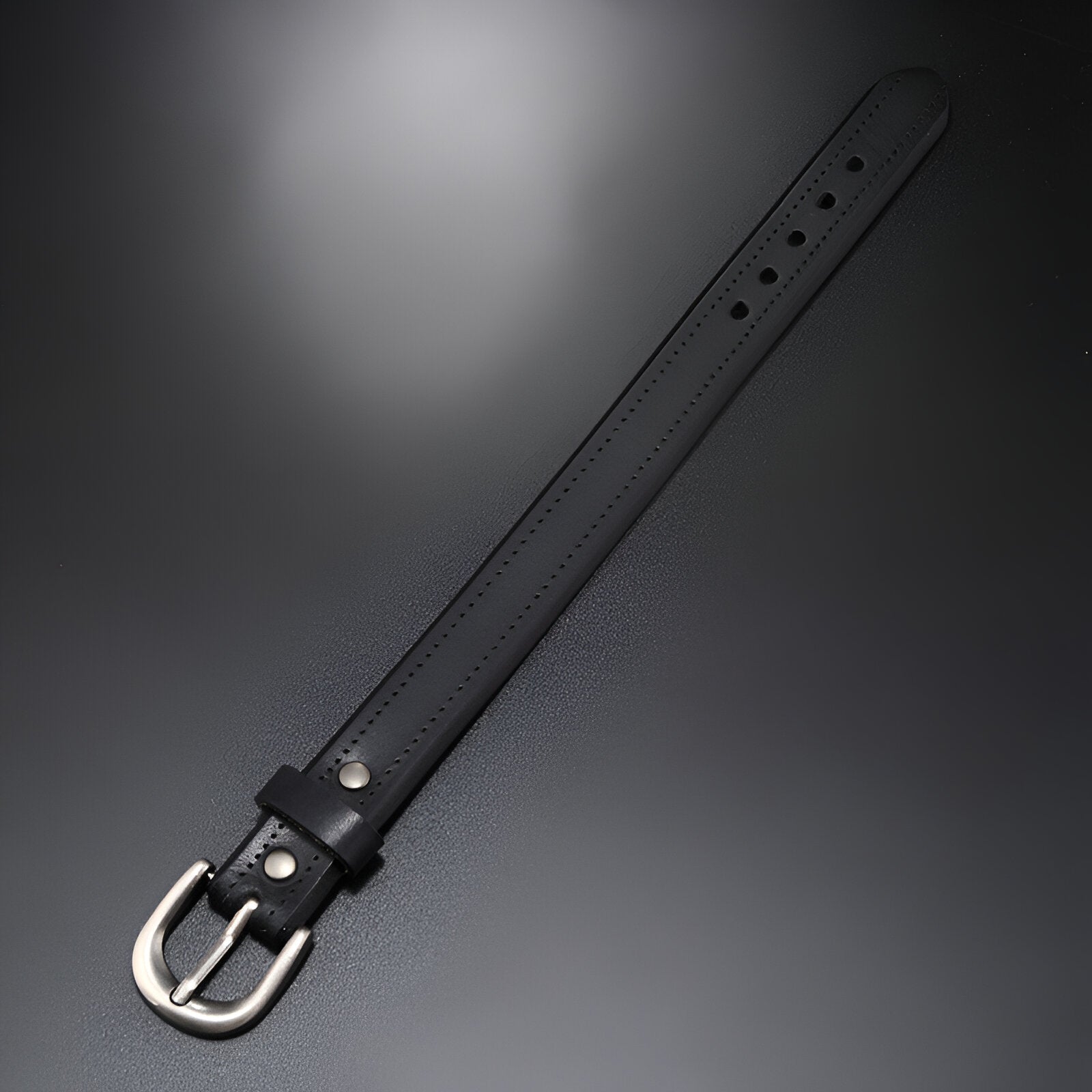 Bracelet noir en cuir avec boucle ardillon argentée et coutures ton sur ton.