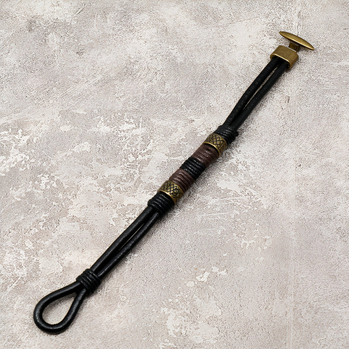 Bracelet homme en cuir noir avec éléments dorés et détails tressés style égyptien Horus.