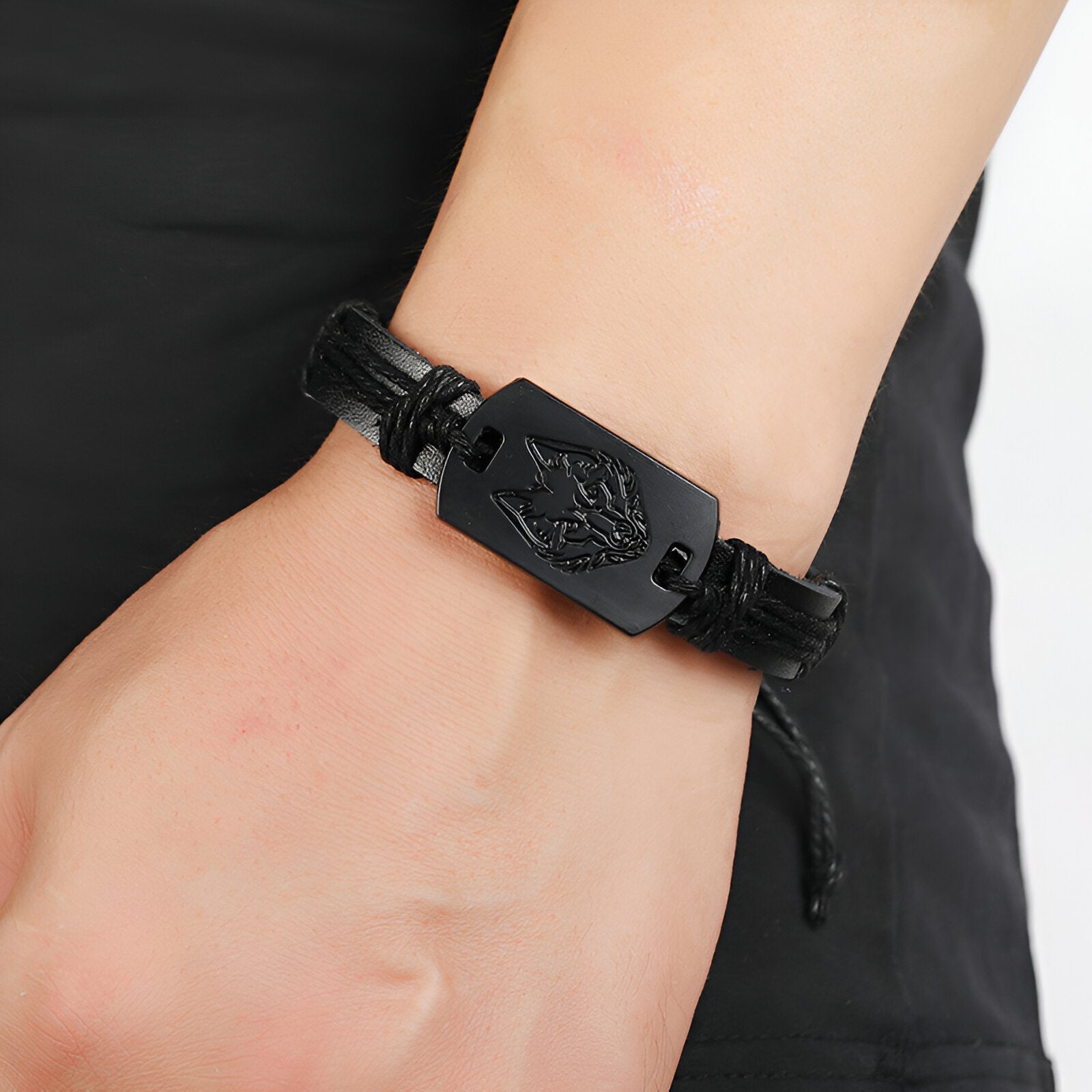 Bracelet en cuir noir avec plaque hexagonale gravée tête de loup, fermoir ajustable.