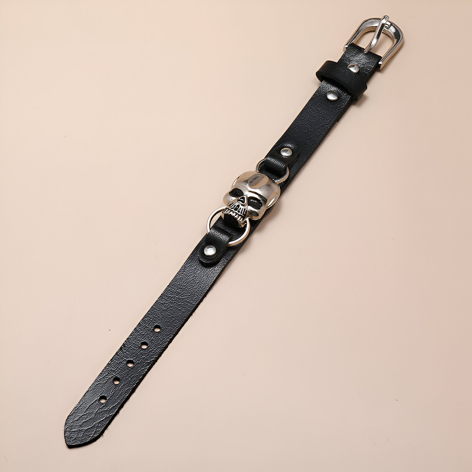 Bracelet en cuir noir pour homme avec tête de mort argentée et boucle à ardillon.