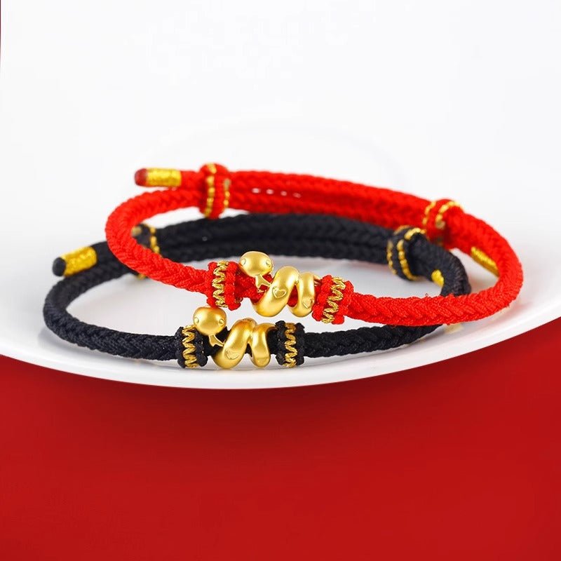 Bracelets en fil rouge et noir ciré avec serpent doré enroulé, symboles de transformation et d'intelligence.