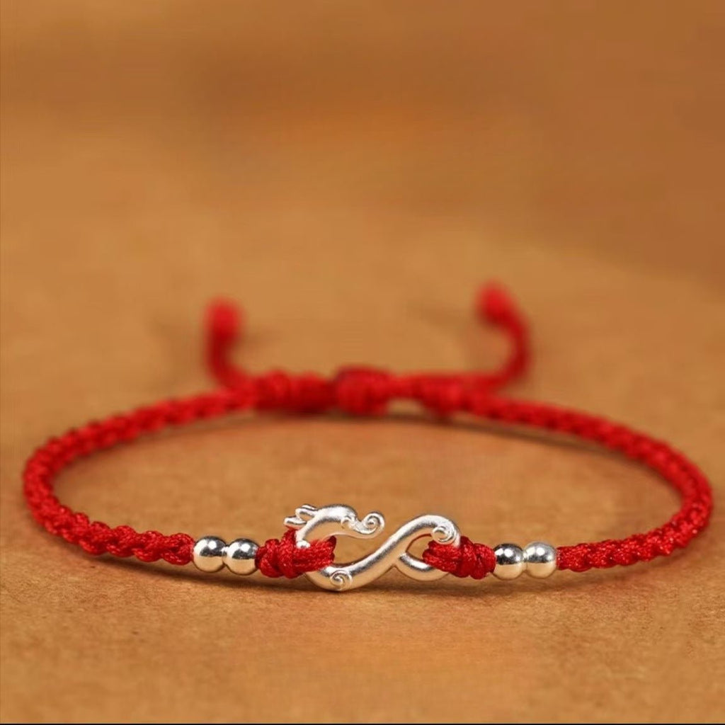 Bracelet rouge en fil ciré avec symbole infini et détails en métal argenté, style tressé.