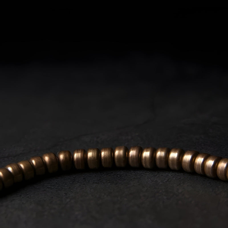 Bracelet femme en laiton marron avec petites perles cylindriques lisses, style minimaliste.