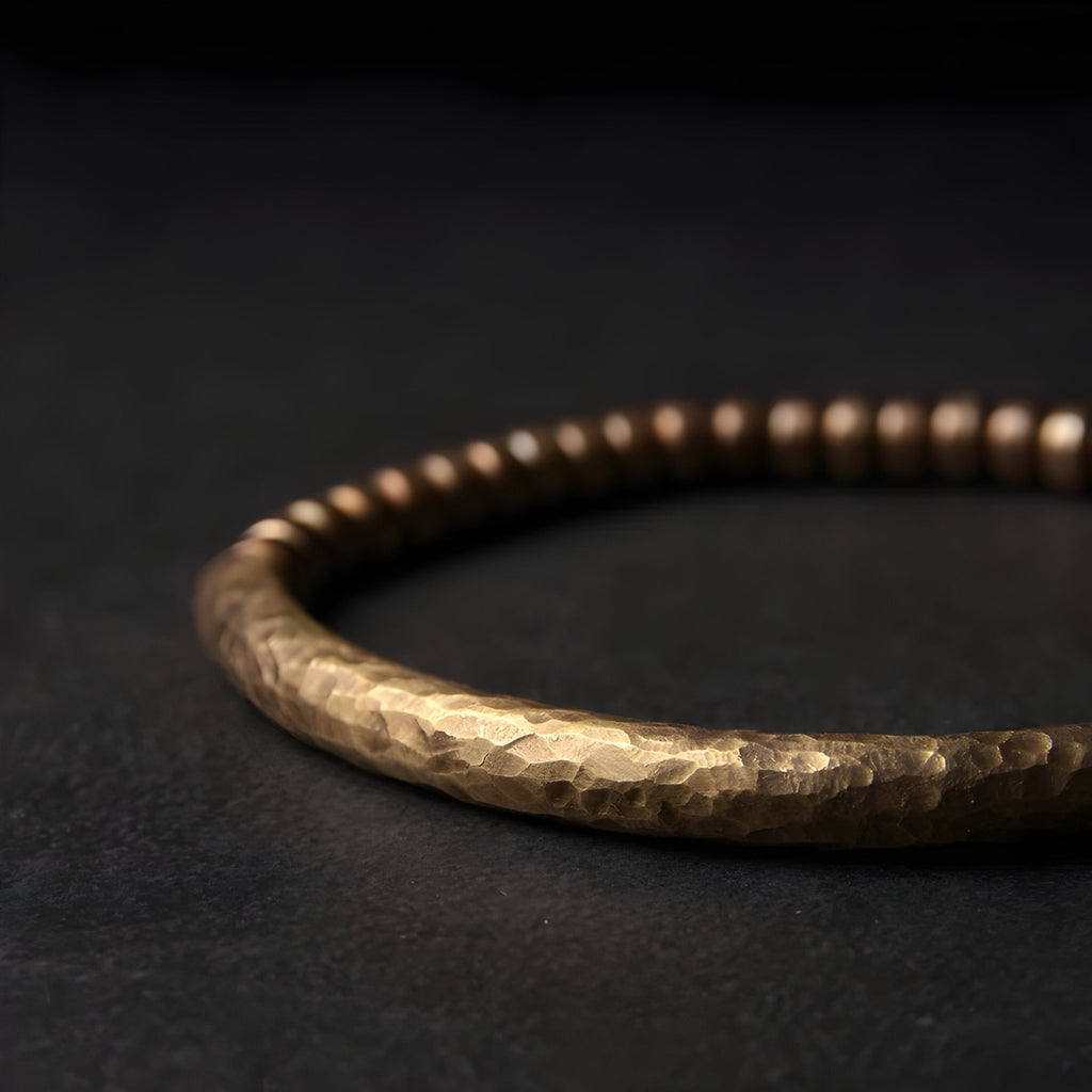 Bracelet en laiton martelé avec petites perles marron, finition texturée élégante.