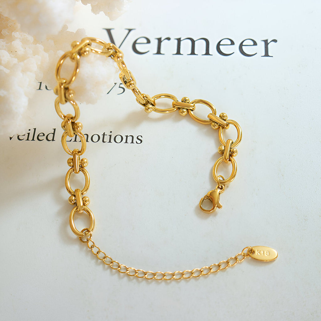 Bracelet en maille marine doré en titane plaqué or avec fermoir et chaîne de réglage.