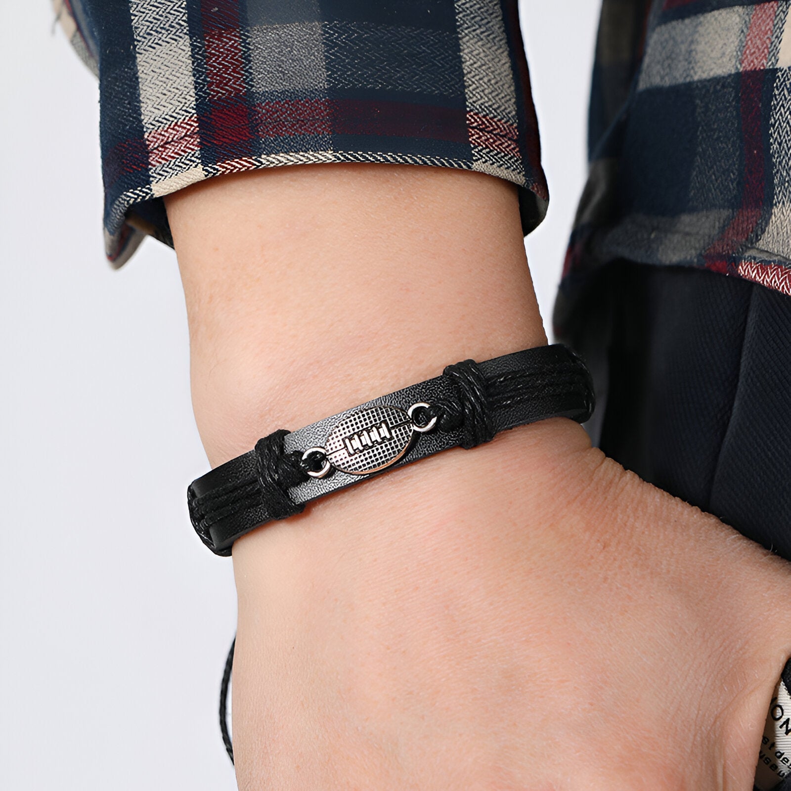 Bracelet noir en microfibre avec décoration ballon de rugby métallique, style masculin.