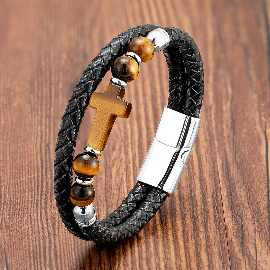 Bracelet en microfibre noire tressée avec perles œil de tigre et croix chrétienne en pierre, fermoir métallique argenté.
