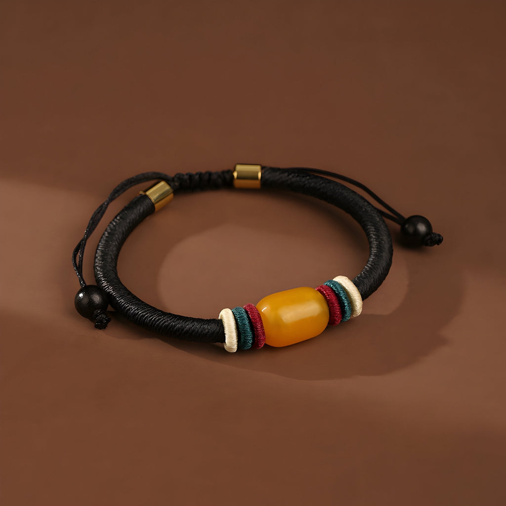 Bracelet mixte en nylon noir avec pierre d'ambre jaune et anneaux colorés rouge, bleu et blanc.