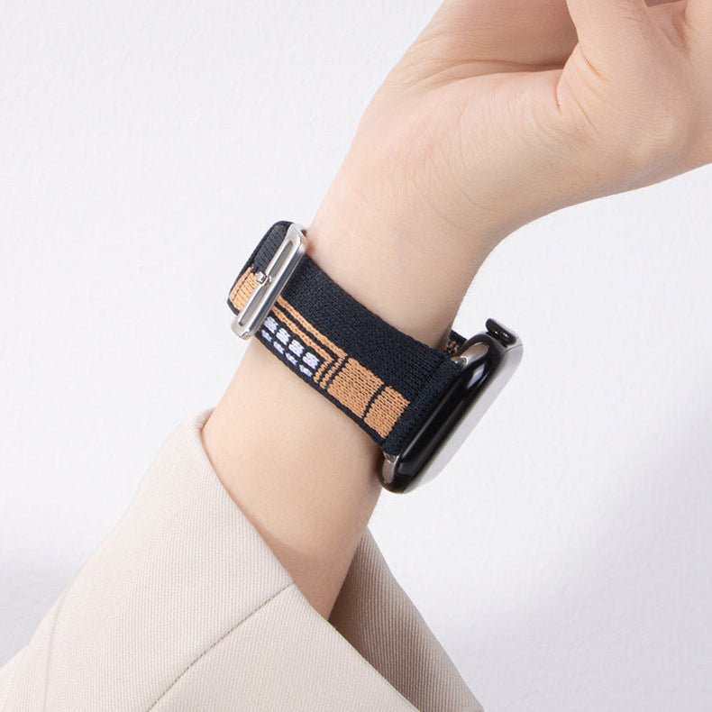 Bracelet Apple Watch en nylon tissé noir avec motifs beige, boucle classique argentée, style urbain moderne.