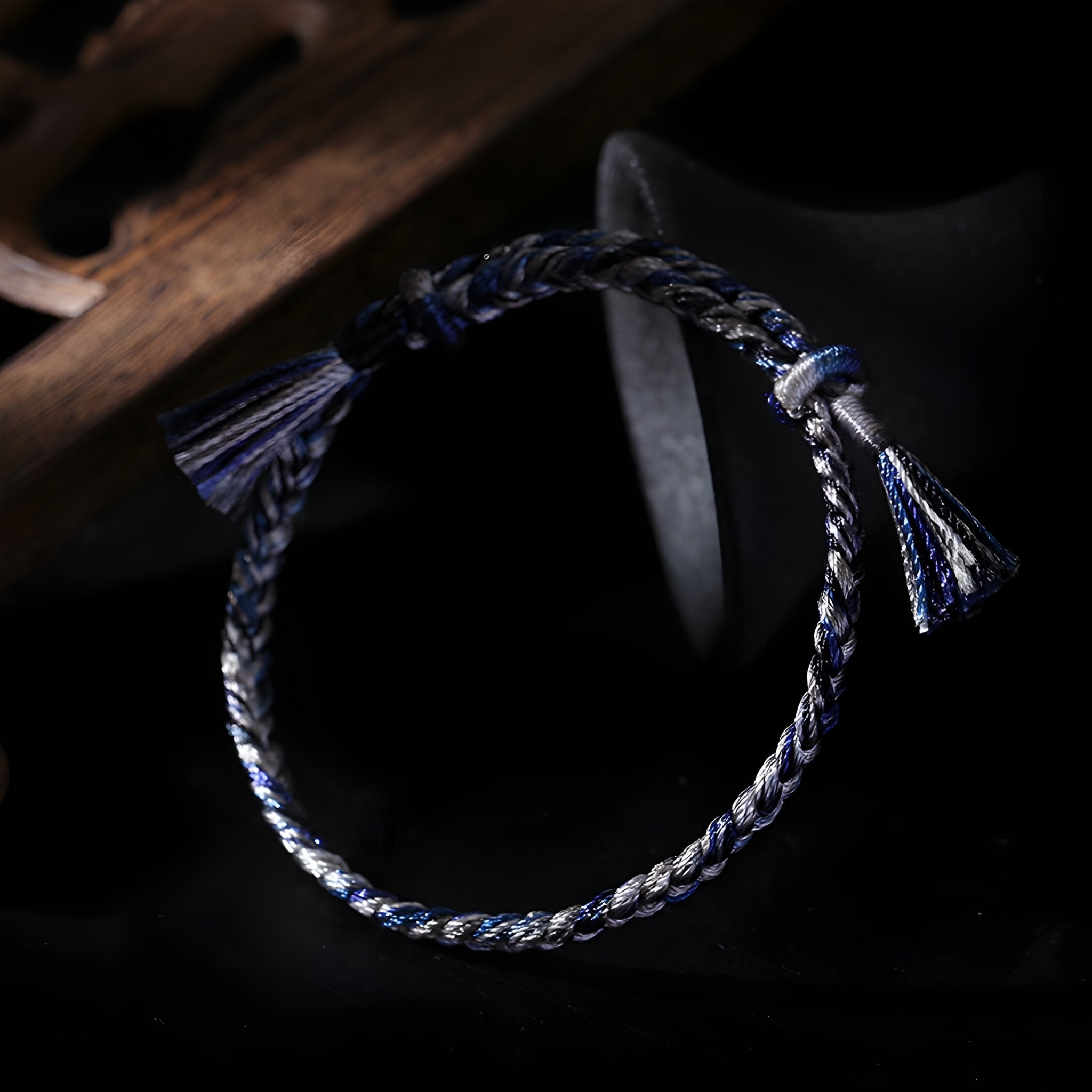 Bracelet en nylon tressé bleu et blanc avec pompons aux extrémités féminins et délicats.