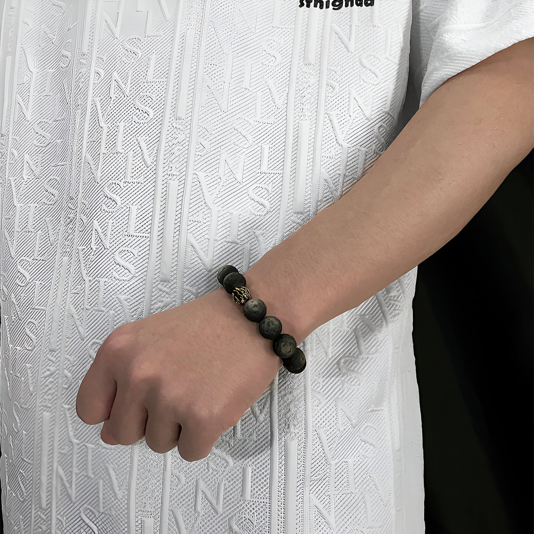 Bracelet homme en perles rondes noir obsidienne effet pierre de Lune sur poignet.
