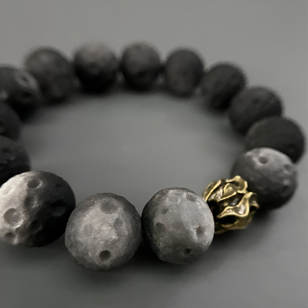 Bracelet homme perles noires effet pierre de Lune avec détail métal doré texturé.