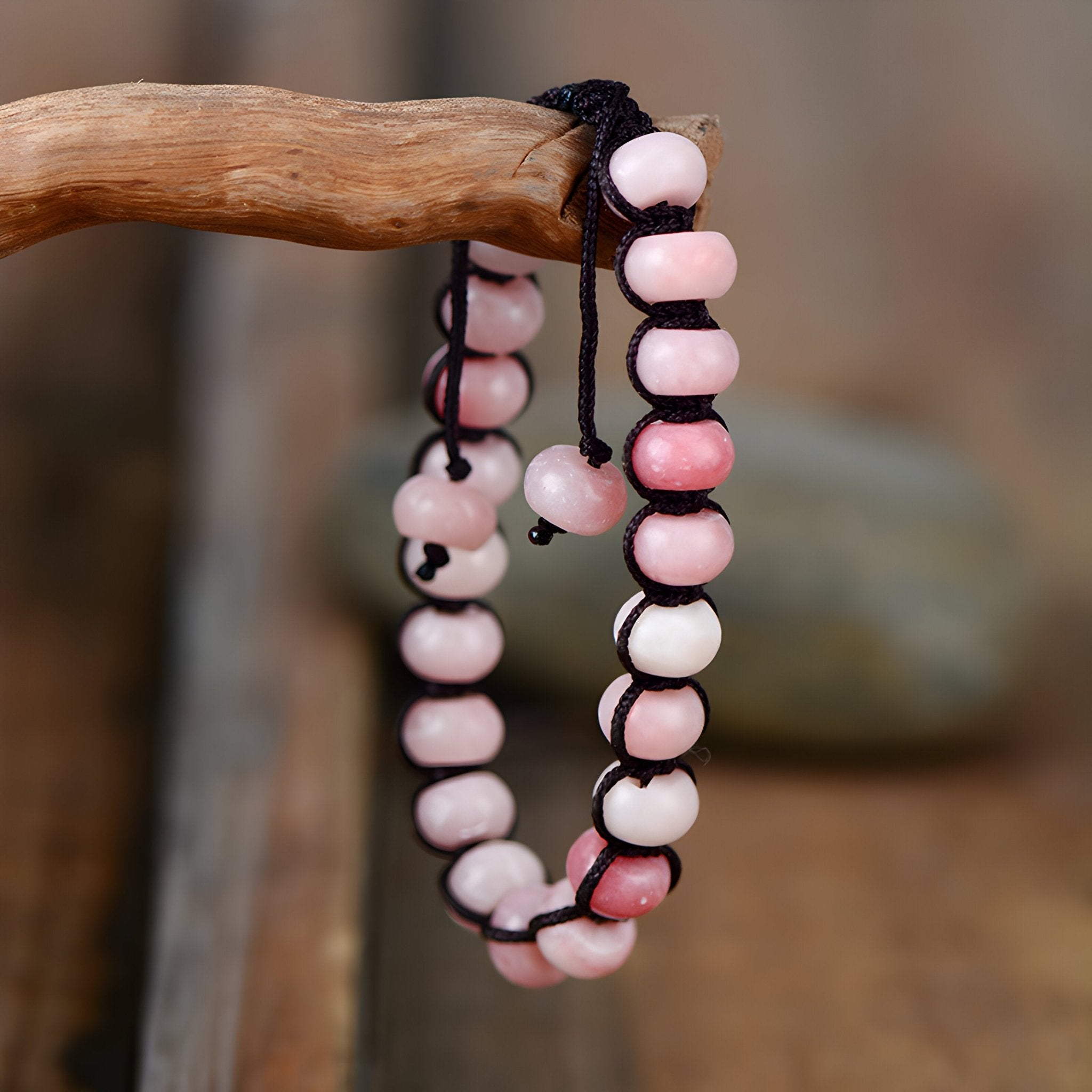 Bracelet multi-rangs en pierres naturelles d'opale rose montées sur cordon noir réglable.