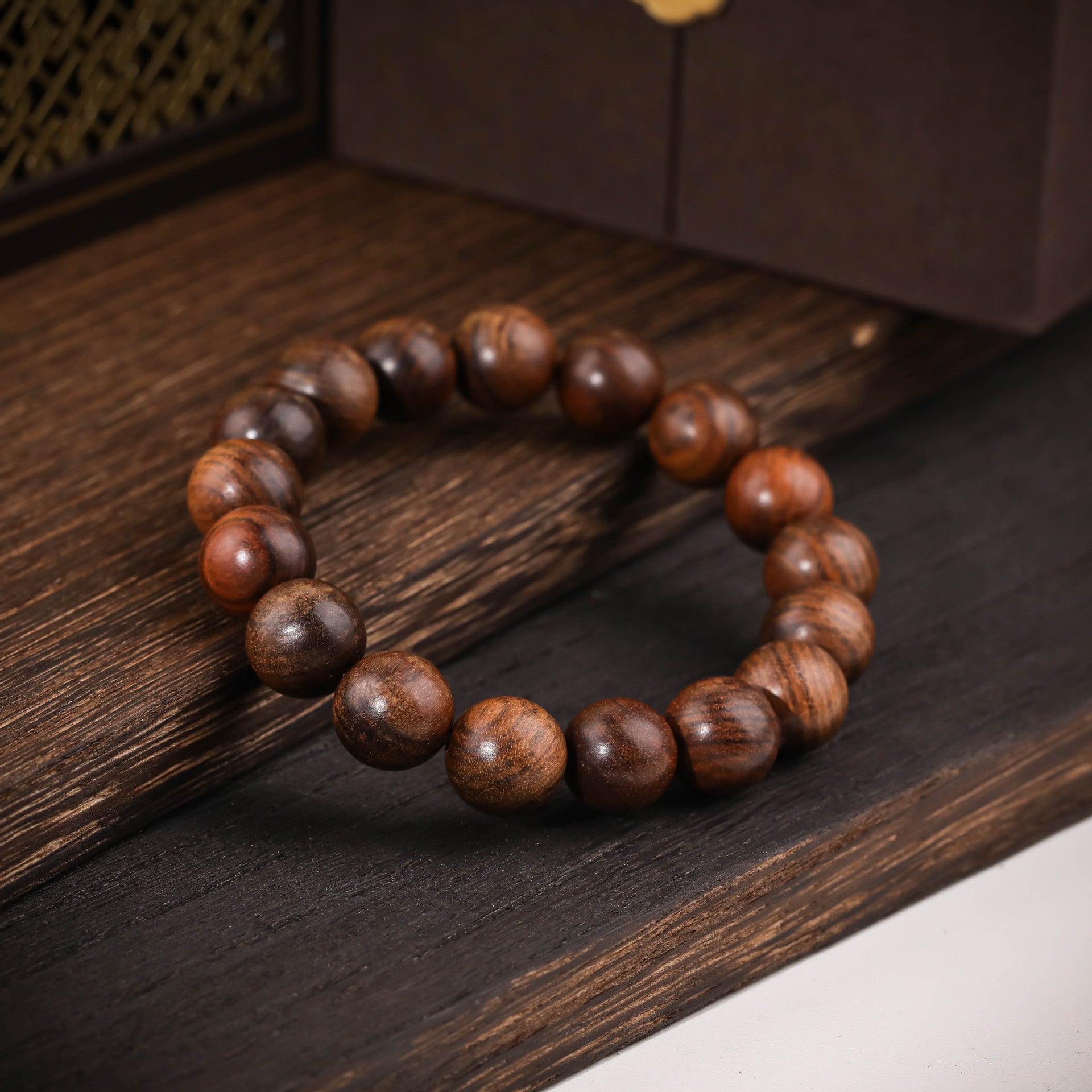 Bracelet élastique composé de perles rondes en bois de rose marron aux tons chauds et naturels.
