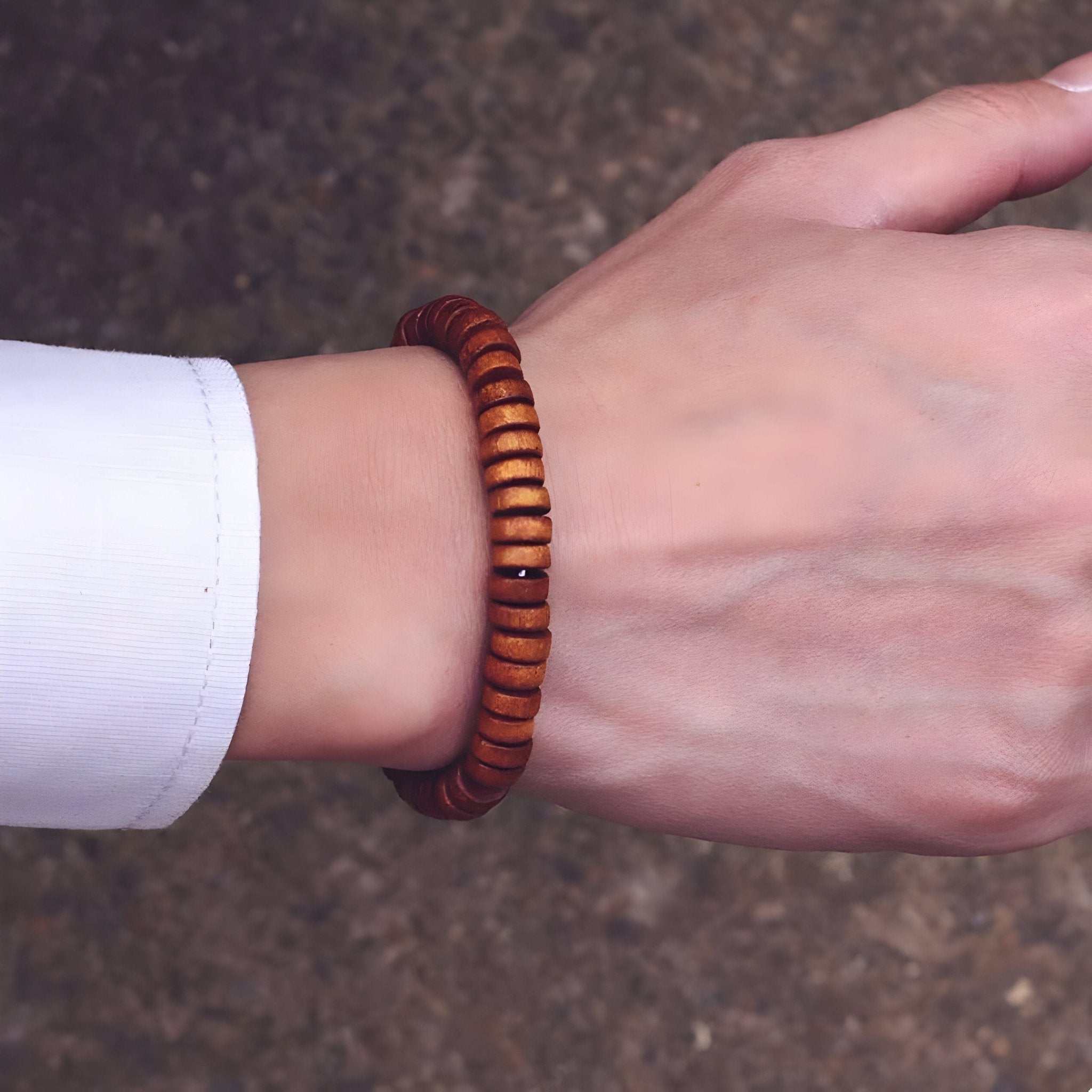 Bracelet homme en perles de bois marron, style naturel, porté au poignet.
