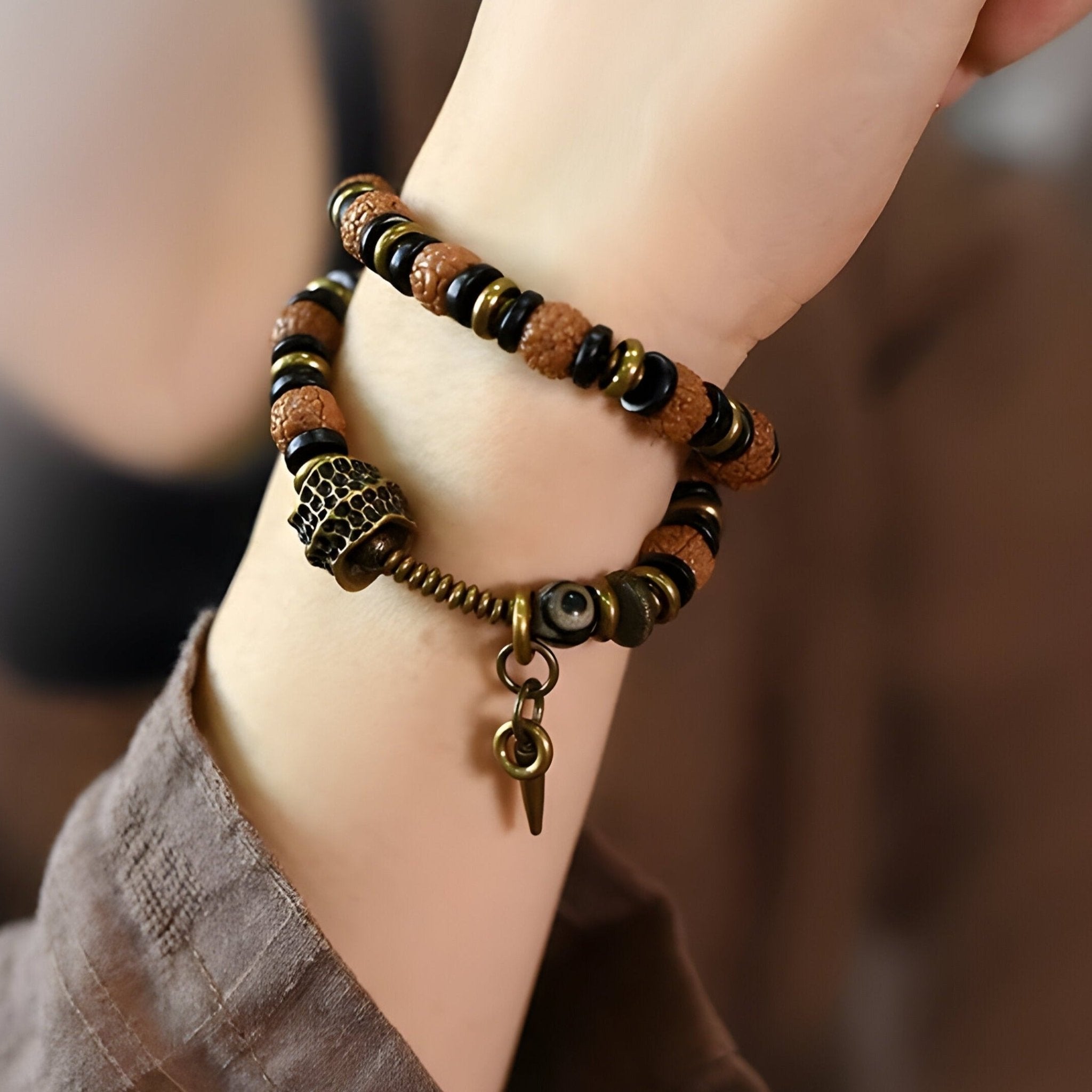Bracelet femme en perles marron de Rudraksha et bois d’ébène avec breloque et détails en cuivre.