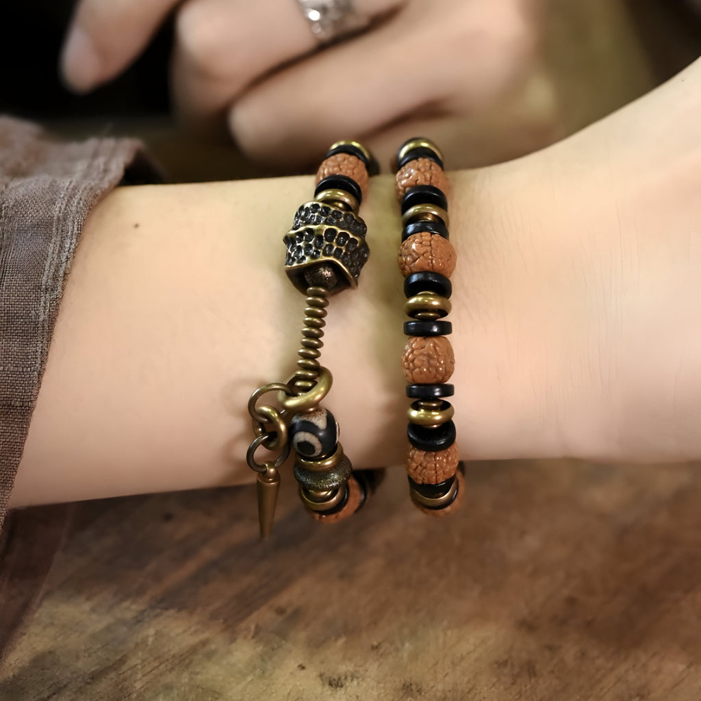 Bracelet double en perles de Rudraksha marron et bois d'ébène noir avec fermoir en cuivre sur poignet féminin.
