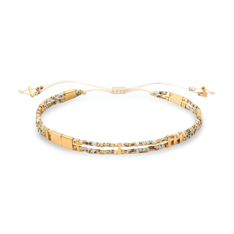 Bracelet double-rangs beige avec perles du Japon et détails dorés, cordon ajustable.