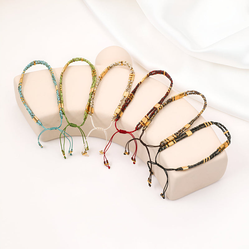 Cinq bracelets en perles japonaises double-rangs ajustables, couleurs bleu, vert, beige, bordeaux et noir, présentation sur.