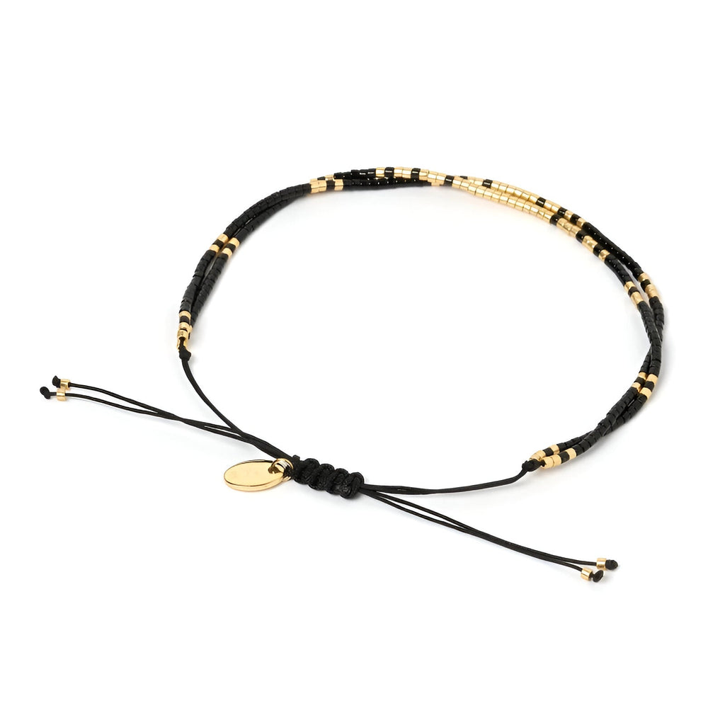 Bracelet double-rangs en perles noires avec accents dorés et fermeture ajustable en cordon noir.