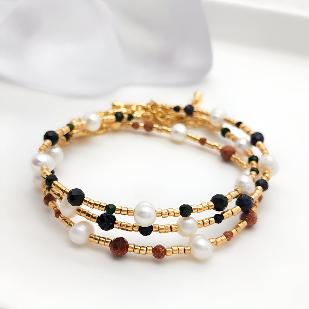 Bracelet femme multi-rangs en perles dorées, pierres de grès marron, perles noires et blanches élégantes.