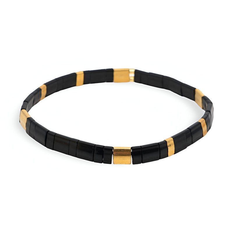 Bracelet élastique femme en perles noires et dorées, style minimaliste et moderne.