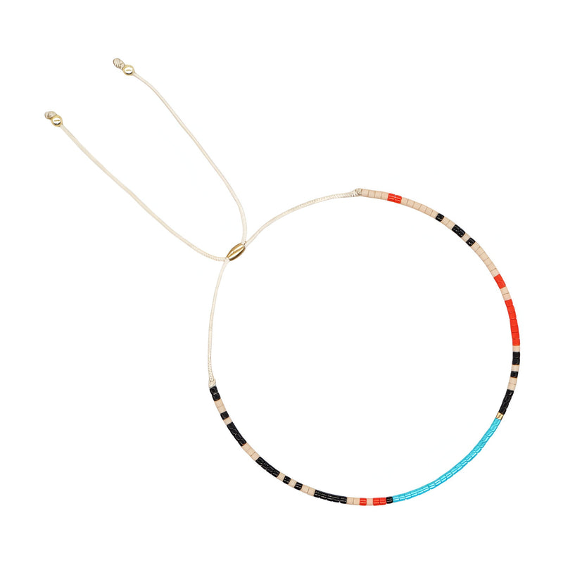 Bracelet fin en perles japonaises multicolores bleu, rouge, noir et beige avec cordon ajustable doré.