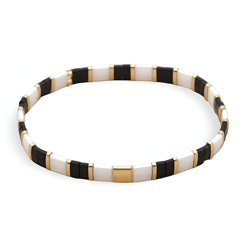 Bracelet fin en perles japonaises noires, blanches et dorées au design rectangulaire élégant.