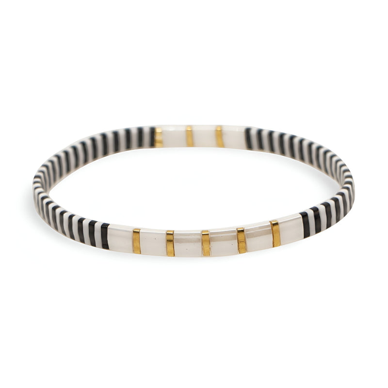 Bracelet en perles fines blanches et noires avec motifs dorés élégants et délicats.