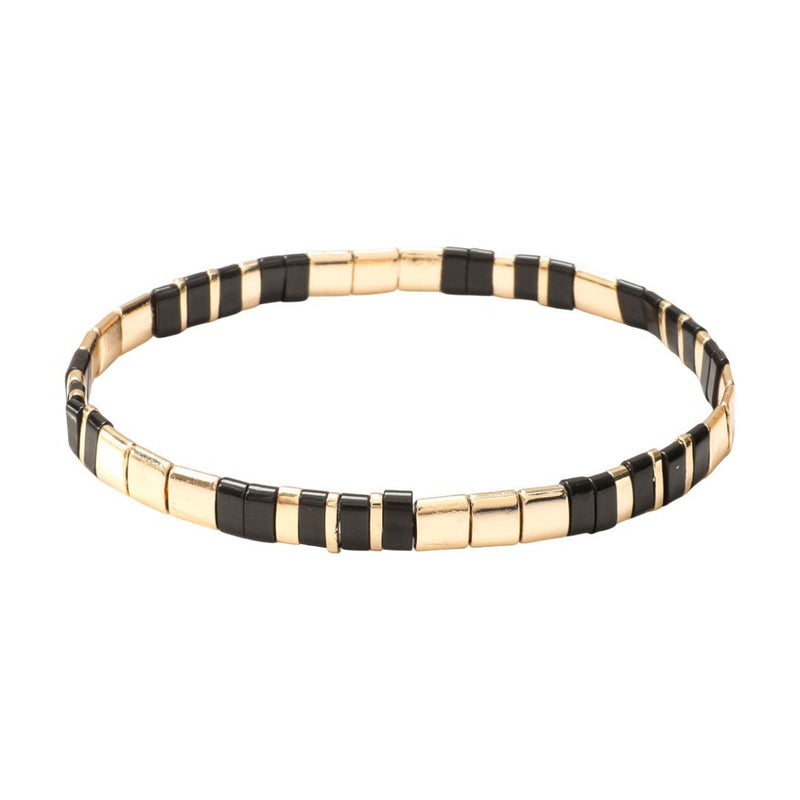 Bracelet souple à enfiler en perles tubulaires dorées et noires alternées, design minimaliste et élégant.
